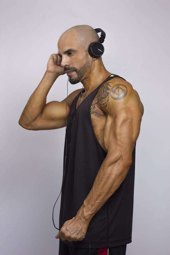 Brawny Man in Black Tank Top Wearing Black Headphones