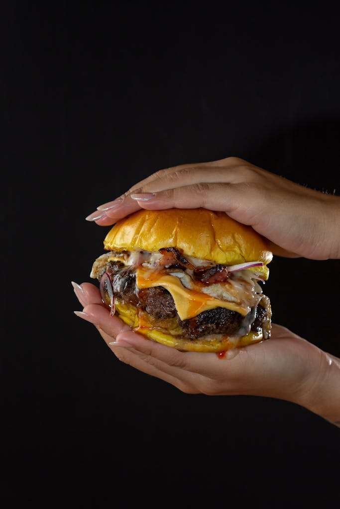 Close-up of Woman Holding a Cheeseburger