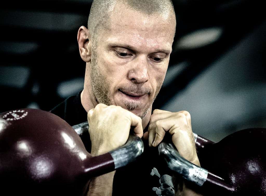 Man Holding Kettle Bells
