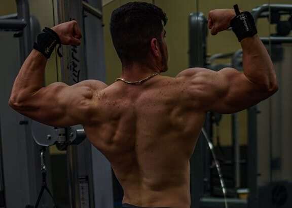 Back View of a Muscular Man Exercising in a Gym