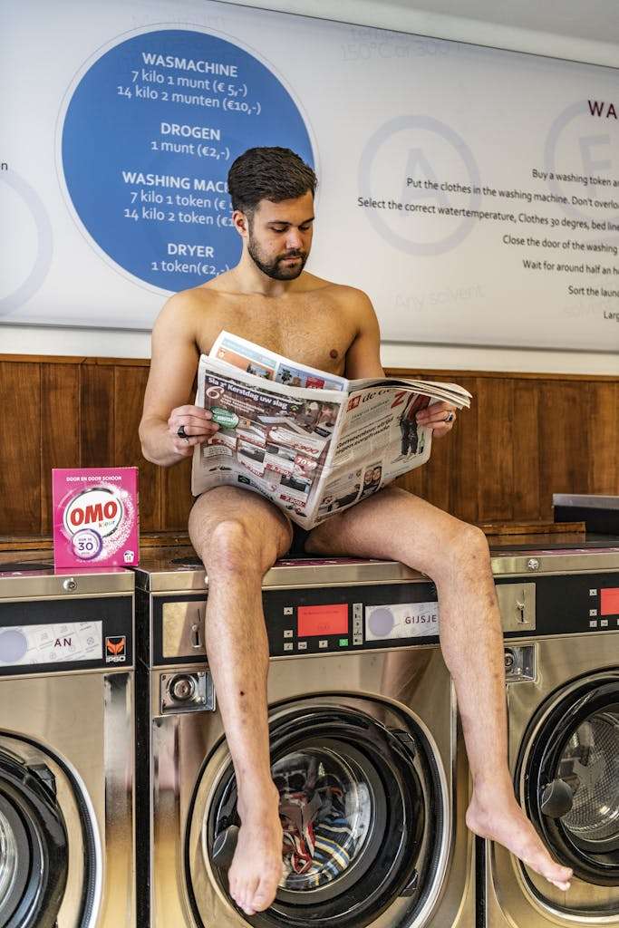 Man Sitting on Front-load Clothes Washer