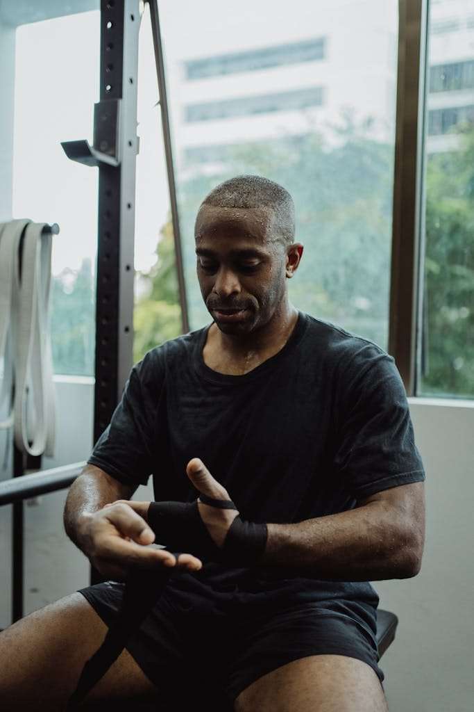 Sweaty Man in Black Shirt Resting in Gym